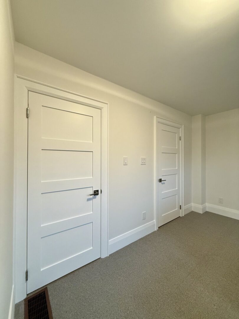 White room with two closed doors.