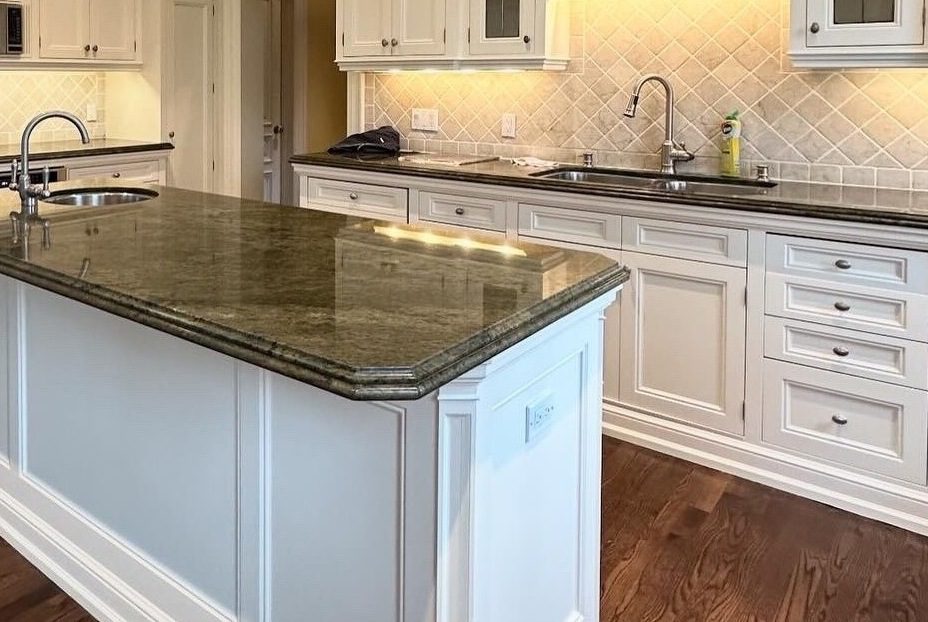 Elegant kitchen with a marble island and white cabinetry.