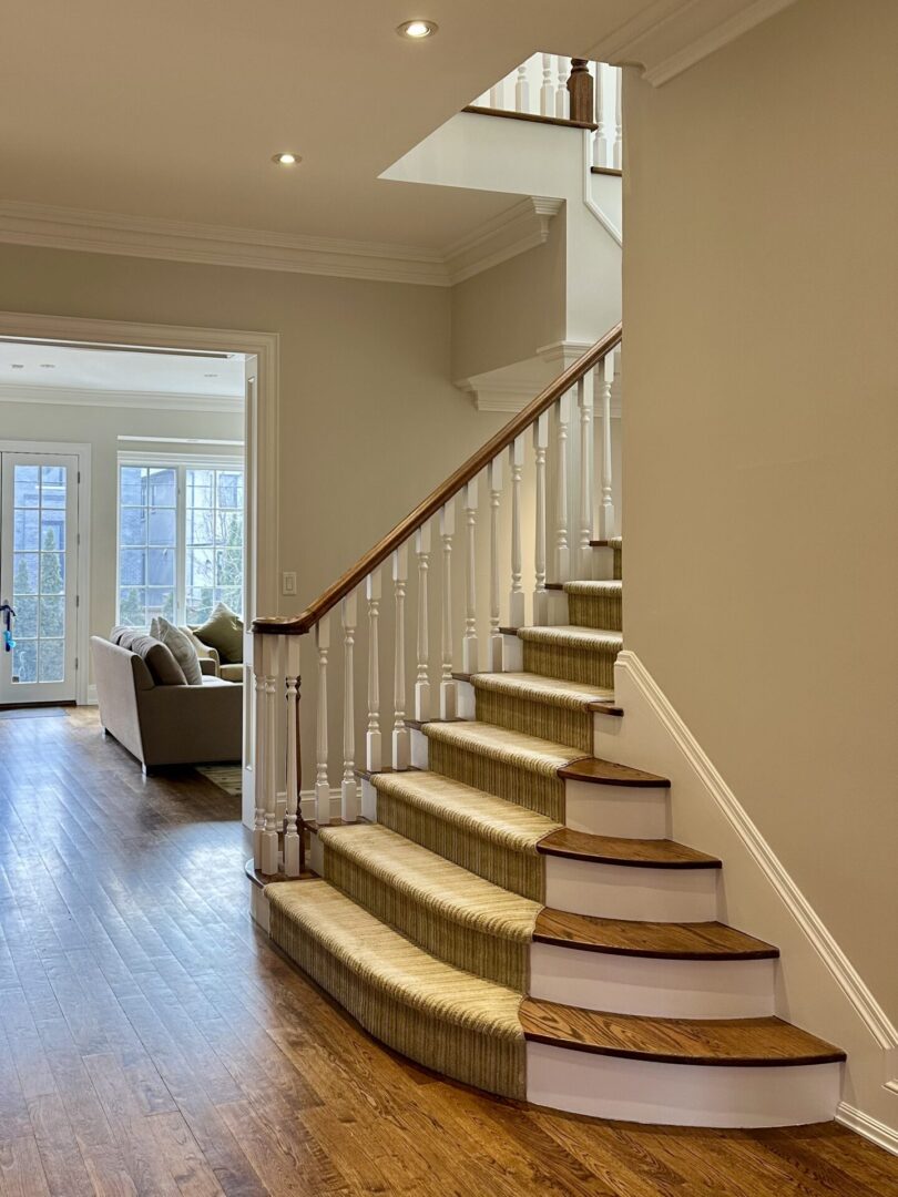 Elegant staircase with carpet runner in a cozy, well-lit home interior.