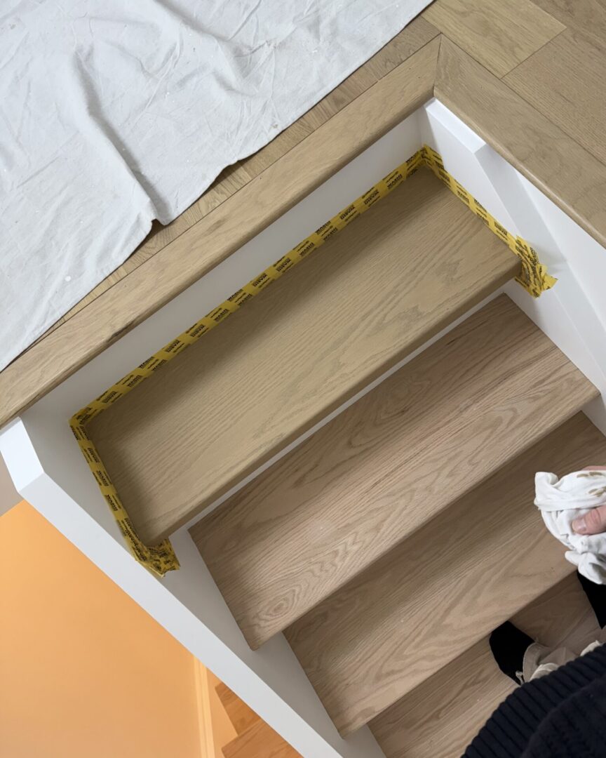 Wooden staircase with protective tape on the edges during installation.