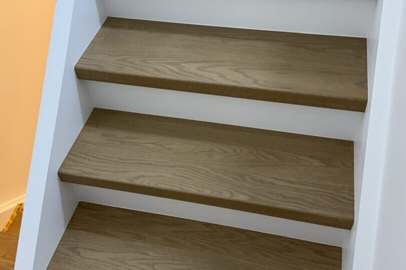 Three wooden steps of a staircase with a minimalist design.