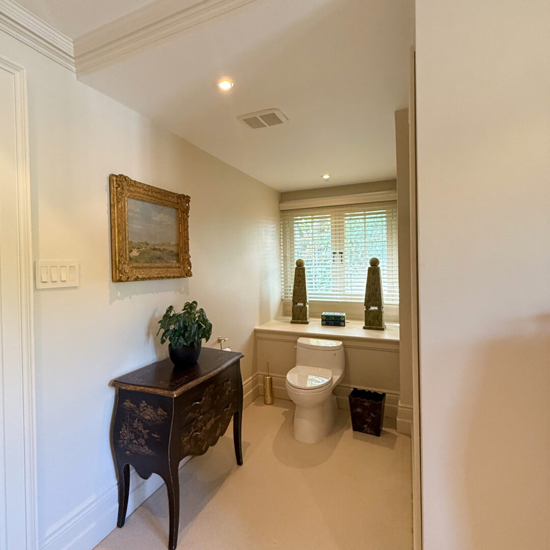 Elegant bathroom with classic wooden furniture and large window.