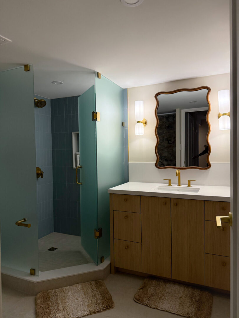 Modern bathroom with teal shower and gold fixtures