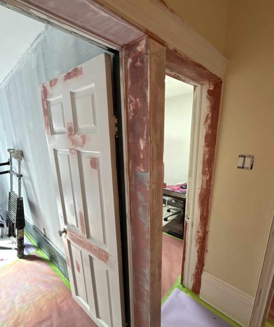 Partially open white door with unfinished wall around the frame.