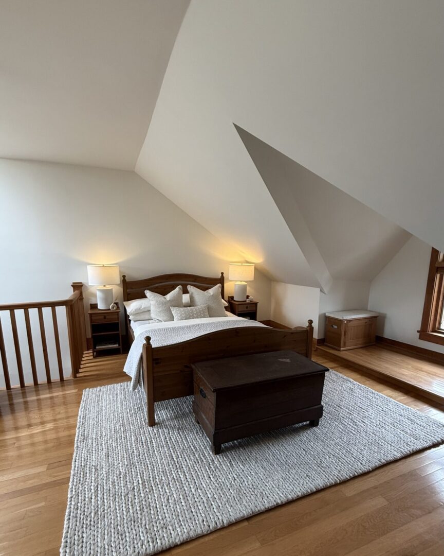 Cozy bedroom with slanted ceiling and warm lighting.