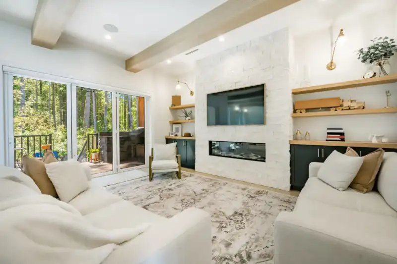 Modern living room with large windows and fireplace.
