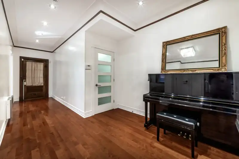 Hallway with piano and large mirror.