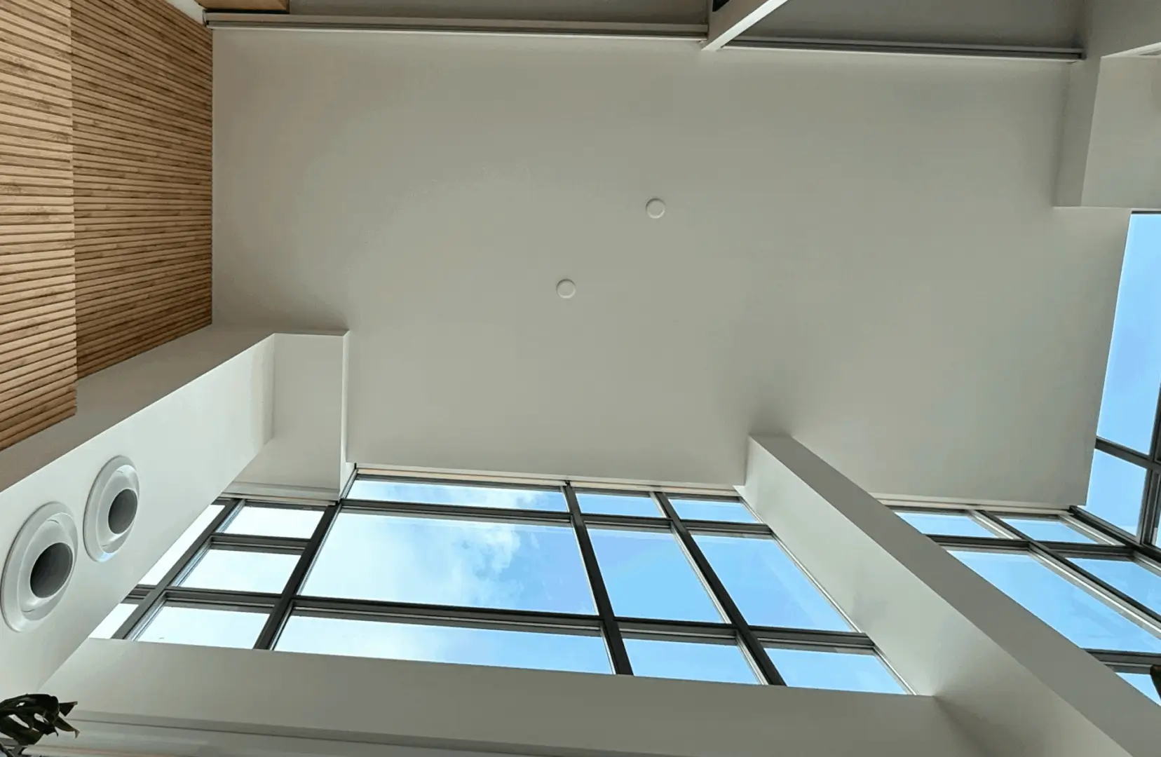 Modern ceiling with skylight and white walls in a bright room.